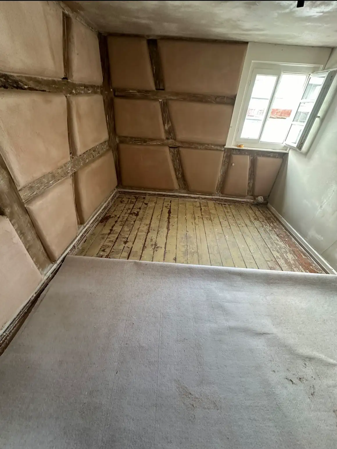Dachgeschossraum mit sichtbarem Fachwerk nach Abschluss der Putzarbeiten