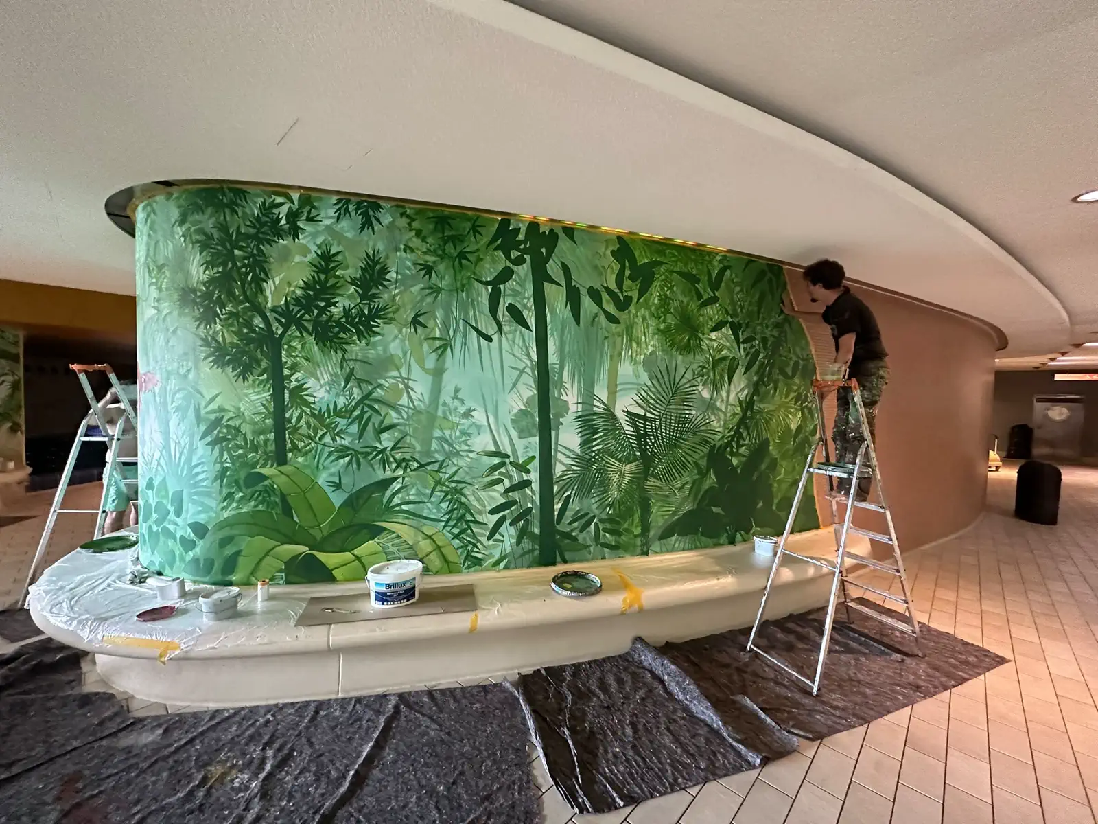 Anbringen einer grossflächigen Dschungel-Tapete auf der gerundeten Wand im Badbereich